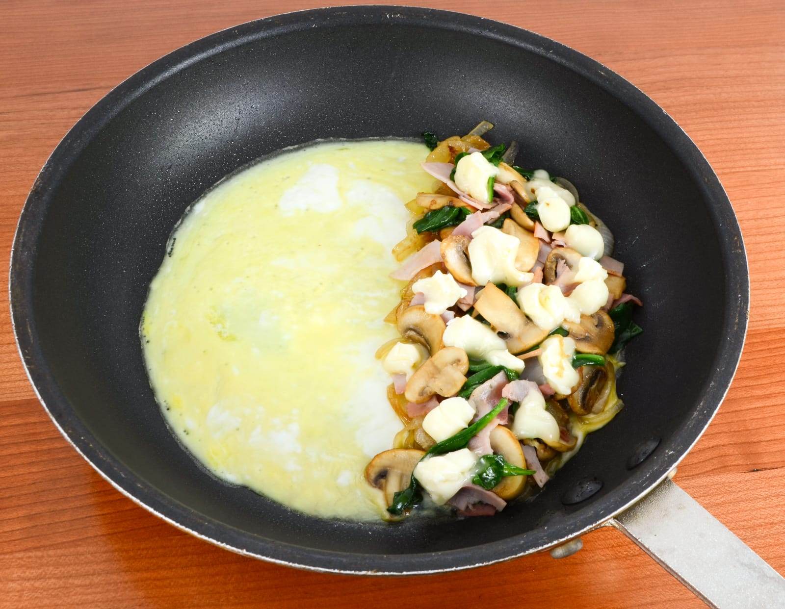 Thin Omelet with Caramelized Onions, Sautéed Mushrooms, Ham, Spinach, and Brie