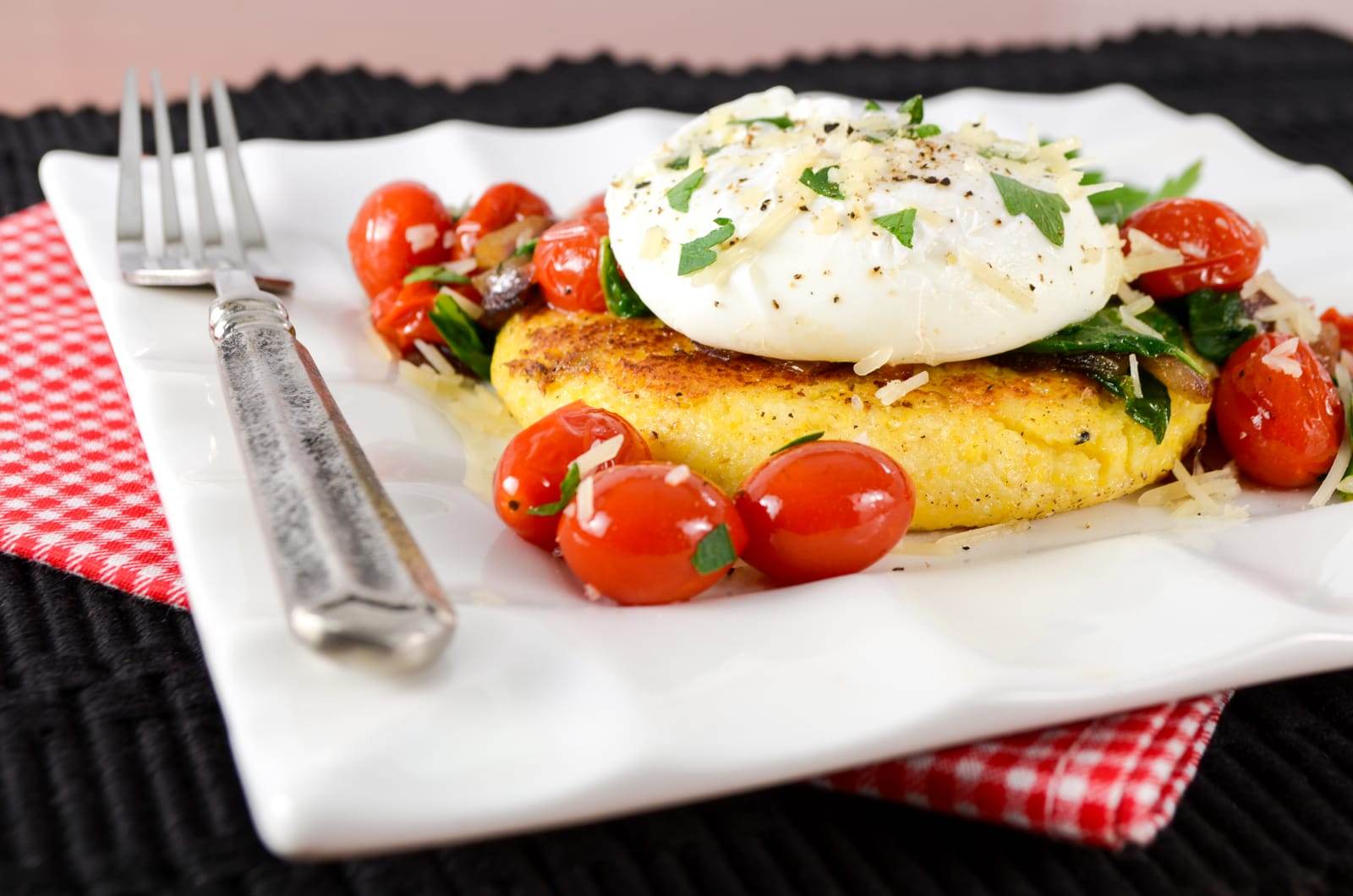 Polenta Cake Topped with Sautéed Tomatoes, Spinach, and a Poached Egg