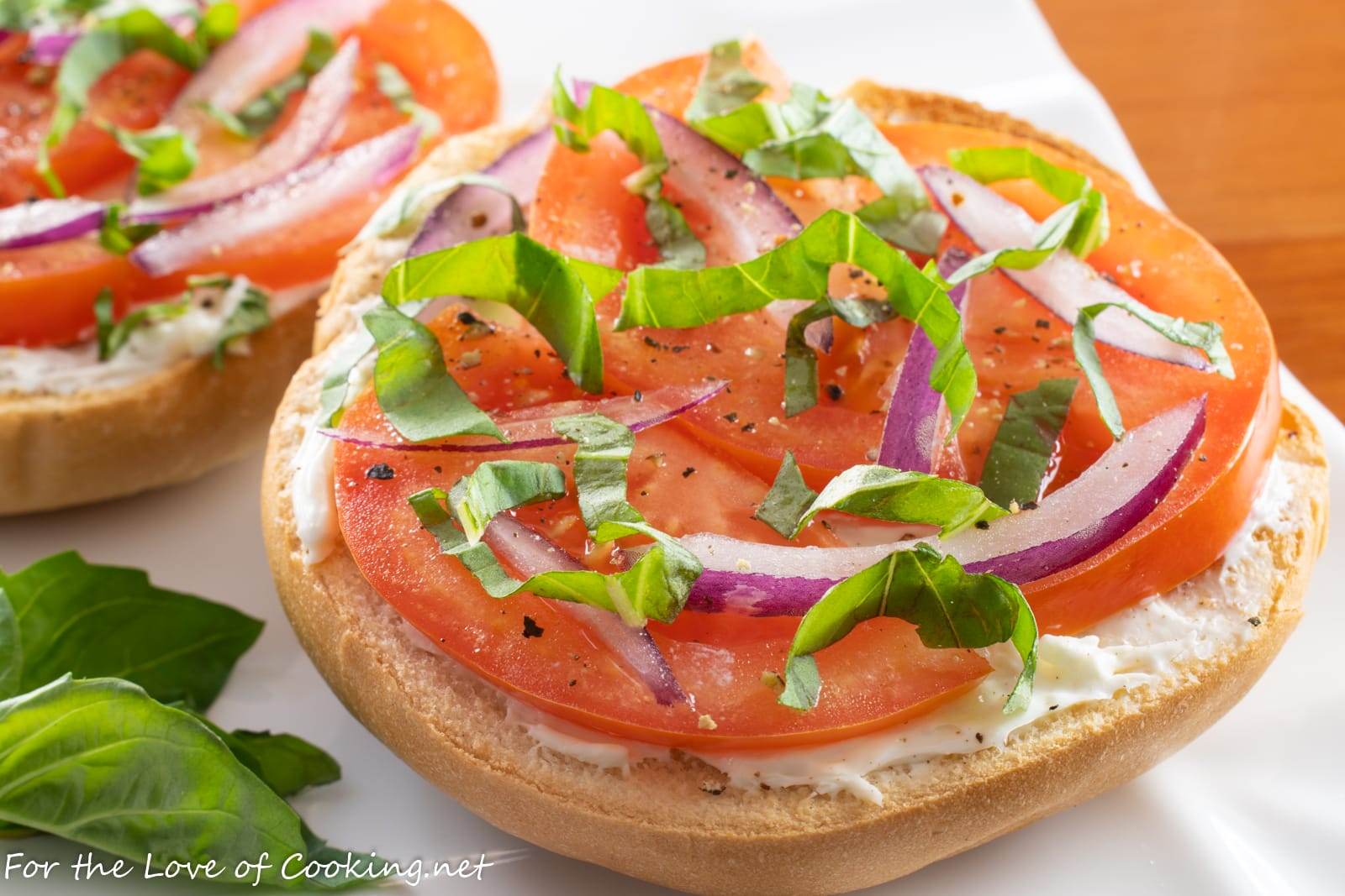 open-faced-bagel-with-cream-cheese-tomato-red-onion-and-fresh-basil